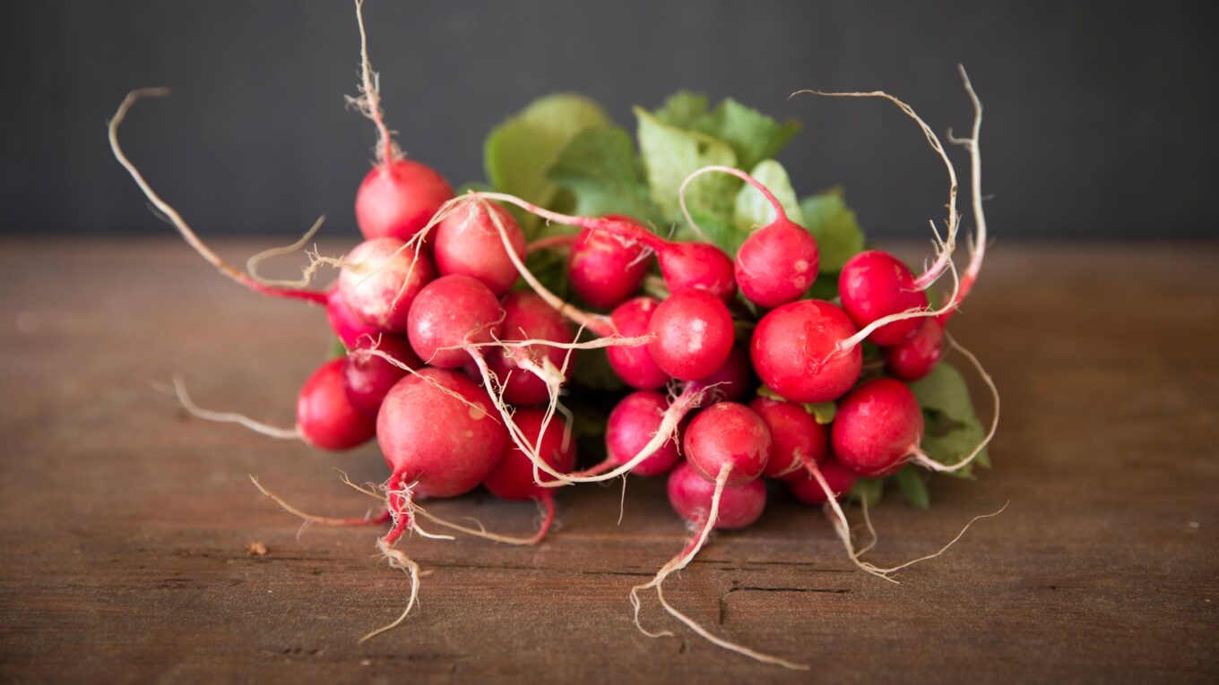 Rote Radieschen auf Holztisch.